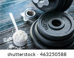 Classic dumbbell with protein powder on wooden table