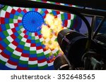 Inside of a colorful hot air balloon as it is inflated for flight, burning burner