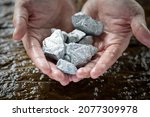 Small photo of Miners hold in their hands platinum or silver or rare earth minerals found in the mine for inspection and consideration