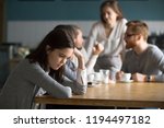 Upset young girl sit alone at coffee table in café feeling lonely or offended, sad female loner avoid talking to people, student outsider suffer from discrimination, lacking friends or company