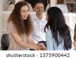 Small photo of Diverse girls guys company members gather together do team building exercises. People at rehab group women holding hands show gratitude and support symbol of reconciliation psychological help concept