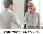 Small photo of Laughing middle aged lady in glasses standing in office handshake with new employee specialist starting career at company, ceo woman welcome client shake hands express regard, nice to meet you concept