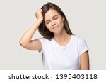 Small photo of Young female closed eyes touches head with hand forgot something important she regrets about mistake feels stressed isolated on grey background studio shot, bad memory absent-mindedness concept image