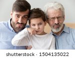 Happy funny multi 3 three generation men family close up portrait, cute child boy son grandson holding finger fake drawn moustache posing with young grown father and old grandfather look at camera