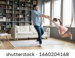 Small photo of Happy young father have fun with little preschooler daughter relax together at home, overjoyed dad dance and swirl sway with excited small girl child, enjoy family weekend in living room