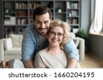 Portrait of grateful adult man hug smiling middle-aged mother show love and care, thankful happy grown-up son in embrace senior 70s mom, enjoy weekend family time at home together, bonding concept