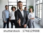Head shot portrait confident smiling businessman offering hand for handshake, looking at camera, friendly hr manager team leader welcoming new worker, making agreement or great deal