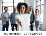Head shot portrait smiling African American businesswoman offering handshake, standing with extended hand in modern office, friendly hr manager or team leader greeting or welcoming new worker