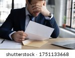 Small photo of Upset male employer or boss sit at desk feel distressed disappointed reading post paper correspondence, unhappy employee frustrated by postal paperwork, get dismissal notice, fired, failure concept