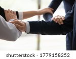 Small photo of Close up businesspeople connected arms standing side by side shoulder by shoulder show business protection, feel unity, corporate spirit save, strength of four, act together towards common aim concept