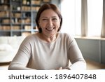 Small photo of Head shot portrait smiling mature woman making video call, grandmother chatting with relatives, using webcam, happy middle aged blogger recording vlog, teacher holding online lesson, distance lecture