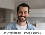 Small photo of Close up headshot portrait of smiling 30s Caucasian man look at camera posing in own flat or apartment. Profile picture of happy 20s male renter or tenant in new home. Real estate, rental concept.
