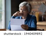 Ugly news. Distressed old age hispanic female check documents at home office read debt bankruptcy information in financial report. Upset stressed older latin woman get bad surprise in official letter