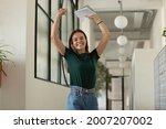 Small photo of Happy excited student celebrating success, passed exam, high test grade, good result. Millennial girl feeling joy, dancing in office corridor. Candidate getting hired after successful job interview