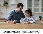 Small photo of Happy dad teaching excited daughter kid to play learning board game at kitchen table. Cheerful girl thinking over next move in checker draughts, training brain skills, Family smart activity concept