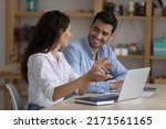 Small photo of Hispanic colleagues sit at desk with laptop discuss corporate software. Mentor provide help to workmate, consider collaborative task. Sales manager and client business meeting in office, tech concept