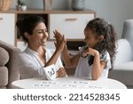 Small photo of Caring Indian mother checks daughter skills in multiplication, family learning together use flash cards, mom praises child give high five gesture. Mathematics basic, preparation for school, education