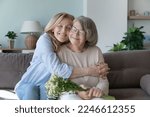 Happy peaceful caring senior daughter woman embracing, tightening elderly mom with affection, devotion, love, visiting old mother, congratulating on birthday, 8 march day, enjoying family leisure