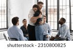 Small photo of Couple of therapy group mates hugging each other on mental health meeting. Diverse team sitting in circle, welcoming teammate returning after absence, giving understanding, embrace and support