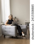 Small photo of Smiling woman enjoy conversation on smartphone seated on cozy armchair with laptop, blab to friend while websurfing page, spend time at home on internet, chatting on-line, call to customer services