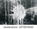 Small photo of Paint splash shape. Leaking paint. Paintball arena splashes. White brush smudge isolated on black metal. Splattet texture. White ink blob. Paint splattered.