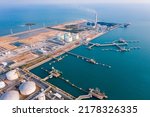 Small photo of Aerial view of Oil refinery and Modern sea harbor with transhipment equipment for oil tankers, oil production plant. Crude oil tanker and Gas lpg tanker container ship, coal powered electricity plant