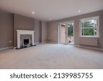 Small photo of Suffolk, England - December 16 2016: Unfurnished modern sitting room with polished iron fireplace