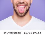 Close-up cropped portrait of attractive, trendy, stylish, toothy man with healthy teeth, showing tongue out, over pastel violet purple background
