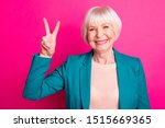 Close-up portrait of her she nice-looking attractive cheerful cheery gray-haired lady wearing blue green jacket showing v-sign isolated over bright vivid shine vibrant pink fuchsia color background