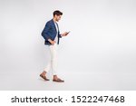 Small photo of Full length body size view of nice attractive trendy cheerful cheery businessman wearing blue checked blazer using cell reading news feed reviewing feedback isolated over light white pastel background