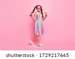 Full length photo of beautiful little lady two cute wavy tails good mood hold big gelato walk street wear colored dress summer sneakers sun specs isolated pastel pink color background