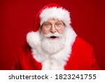 Photo of retired old man grey beard open mouth excited look see magical newyear creature make wish bring atmosphere wear santa costume coat spectacles headwear isolated red color background