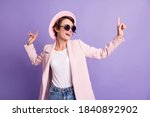 Photo of excited dance disco hit young brunette woman wear cap glasses coat isolated on purple color background