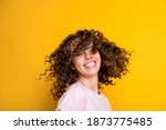 Photo portrait of girl waving curly hair isolated on vivid yellow colored background