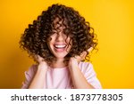 Photo portrait of girl with curly hairstyle wearing t-shirt laughing touching hair isolated on bright yellow color background