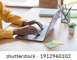 Cropped photo portrait of african american woman's hands typing on laptop in modern office indoors