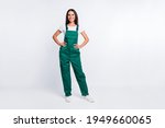 Photo of pretty positive lady hands hips look camera wear green overall isolated white color background