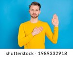 Small photo of Photo of young guy serious confident hand on chest make oath promise isolated over blue color background