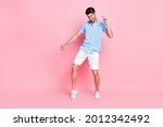 Full length body size photo smiling man in blue shirt dancing at party isolated pastel pink color background