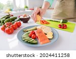 Small photo of Photo of mature woman squeeze lemon juice dish cook gourmet salmon vegetables diet cafe delicious food indoors