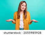 Small photo of Photo of doubtful unsure young woman dressed yellow shirt smiling compare arms empty space isolated teal color background