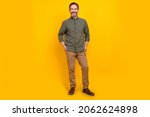 Small photo of Full length body size view of attractive cheerful man employer holding hands in pockets isolated over vivid yellow color background
