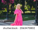 Photo of shiny adorable lady pensioner dressed pink clothes walking smiling outdoors outside city street