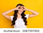 Portrait of attractive cheerful wavy-haired girl showing heart shape sign isolated over bright yellow color background