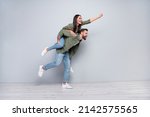 Small photo of Full size profile side photo of young cheerful couple have fun walk strong look empty space isolated over grey color background