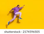 Small photo of Full length body size view of handsome trendy strong cheerful guy jumping striving isolated on vivid yellow color background