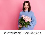 Portrait of young adorable cute smiling woman holding hand roses birthday present isolated on pink color background