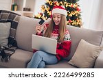 Photo of beautiful excited charming girl sit couch hold debit card use netbook newyear time house indoors