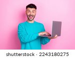 Photo of handsome funny face guy hold his laptop shock eshopping proposition cheap clothes from amazon isolated on pink color background
