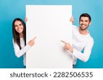 Small photo of Photo of two positive nice people indicate finger empty space proposition isolated on blue color background